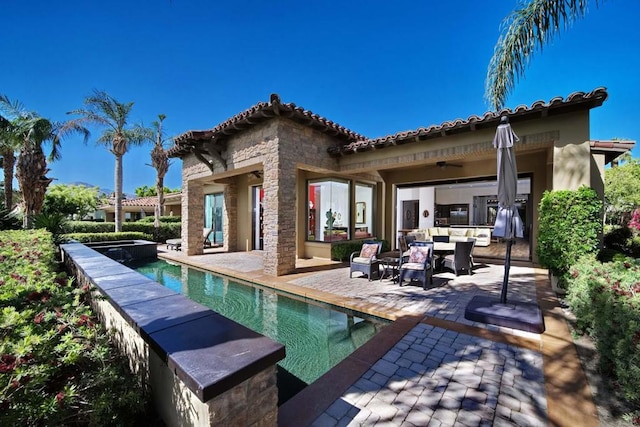 rear view of property with outdoor lounge area, ceiling fan, and a patio area