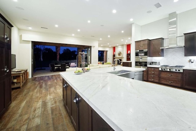 kitchen featuring ventilation hood, sink, tasteful backsplash, dark hardwood / wood-style flooring, and stainless steel appliances