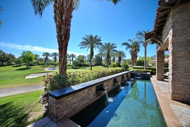 view of swimming pool with a yard and pool water feature