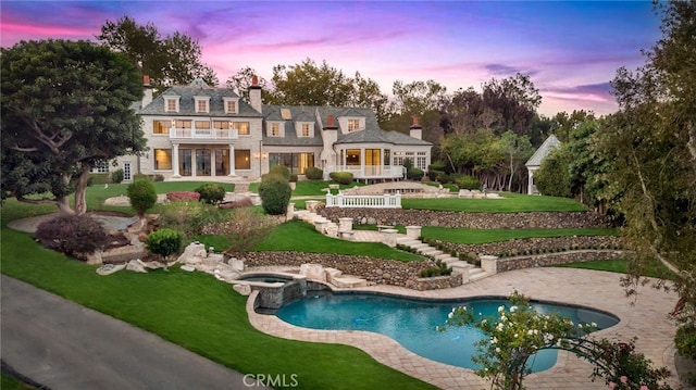 exterior space with a pool with hot tub, a yard, and a patio