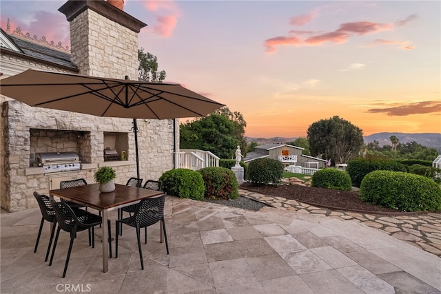 patio terrace at dusk with a mountain view and a grill