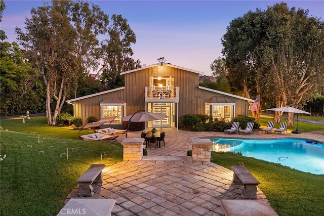 exterior space with a yard, a patio area, and an outbuilding