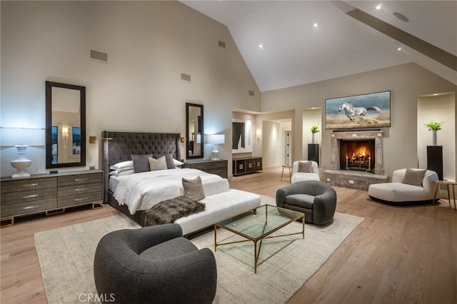 bedroom with light wood-type flooring and high vaulted ceiling