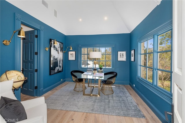 dining space featuring lofted ceiling and hardwood / wood-style floors