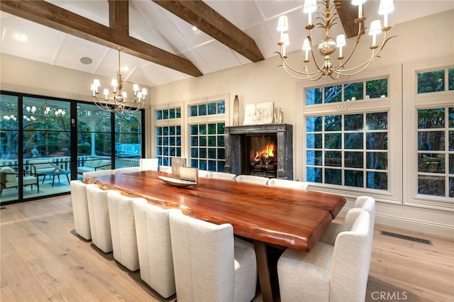 dining space with beamed ceiling, light hardwood / wood-style flooring, a chandelier, and high vaulted ceiling