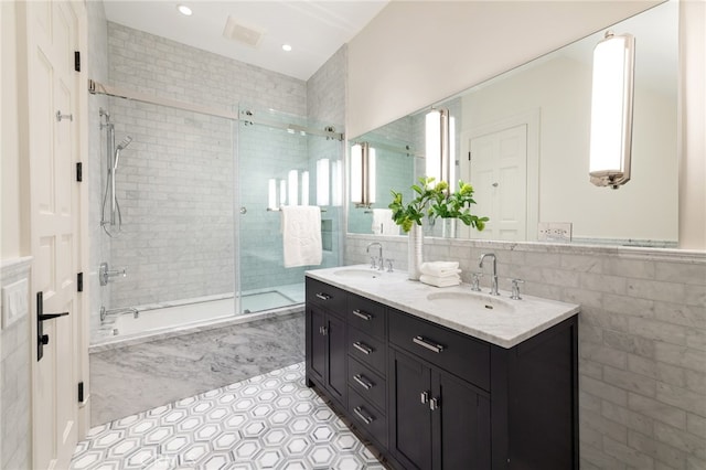 bathroom featuring a wealth of natural light, tile patterned floors, a shower with shower door, and vanity