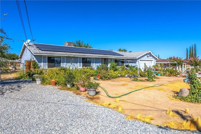 ranch-style home featuring solar panels and a garage