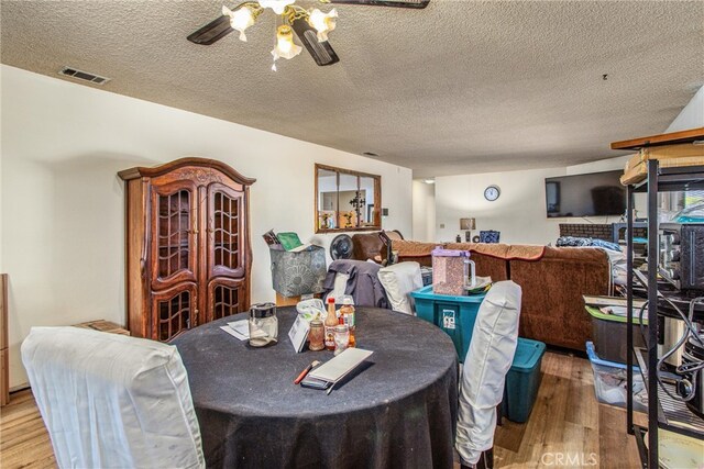 dining room with a textured ceiling, hardwood / wood-style floors, and ceiling fan