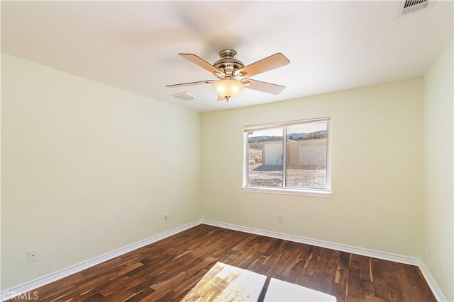 spare room featuring ceiling fan and dark wood-type flooring