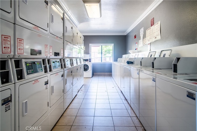 laundry room featuring crown molding, light tile patterned floors, washing machine and clothes dryer, and stacked washing maching and dryer