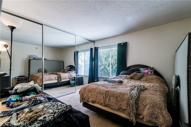 bedroom with a textured ceiling, carpet, and a closet