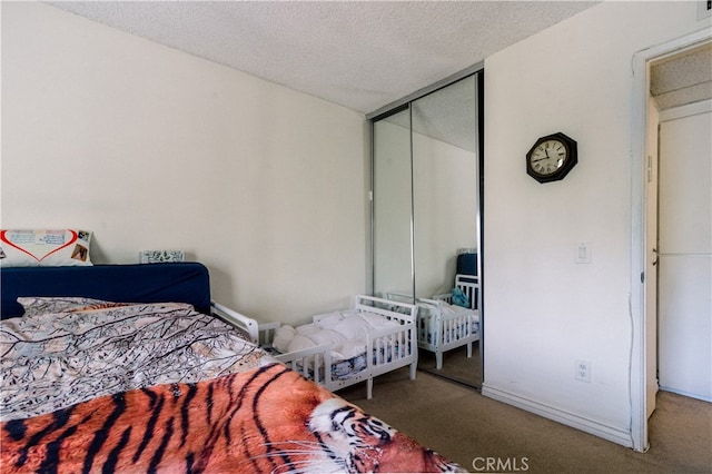 bedroom with a textured ceiling, a closet, and carpet