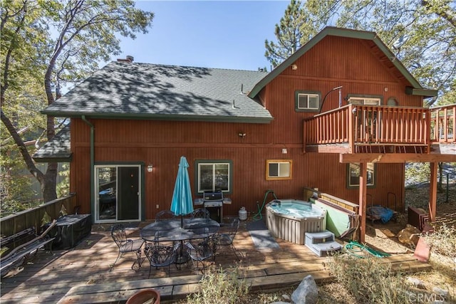 back of house featuring a wooden deck and a hot tub