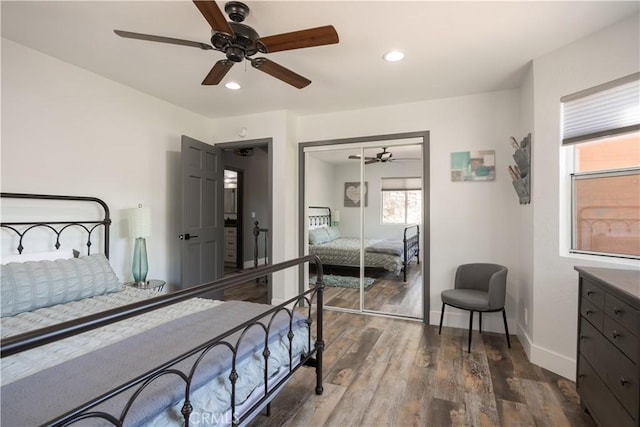 bedroom with dark hardwood / wood-style floors, a closet, and ceiling fan