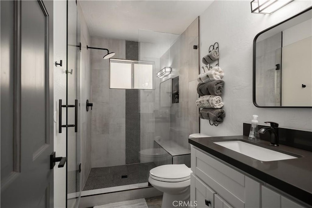 bathroom featuring toilet, an enclosed shower, and vanity