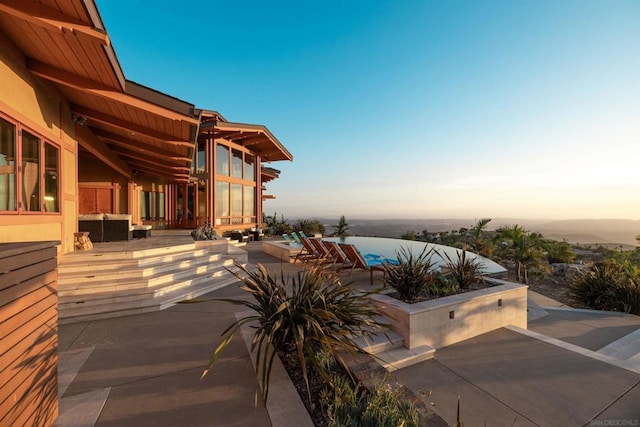 patio terrace at dusk featuring a water view