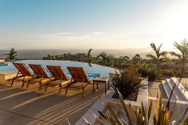 pool at dusk with a patio