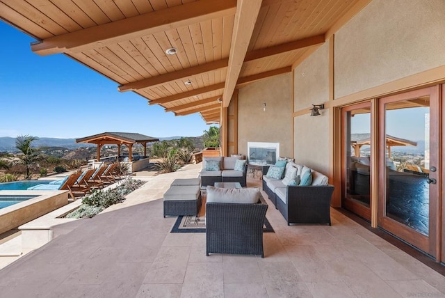 view of patio with a pool with hot tub, a mountain view, and an outdoor hangout area