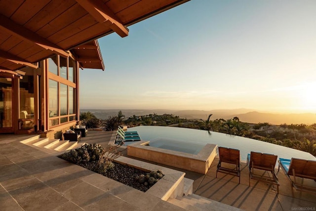 patio terrace at dusk with an in ground hot tub