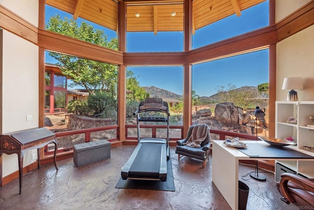 sunroom / solarium with a mountain view, beam ceiling, and wooden ceiling