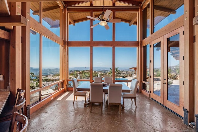 sunroom with vaulted ceiling with beams, ceiling fan, wooden ceiling, and french doors