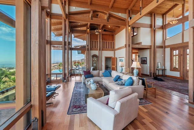 living room with beam ceiling, light wood-type flooring, wooden ceiling, and high vaulted ceiling