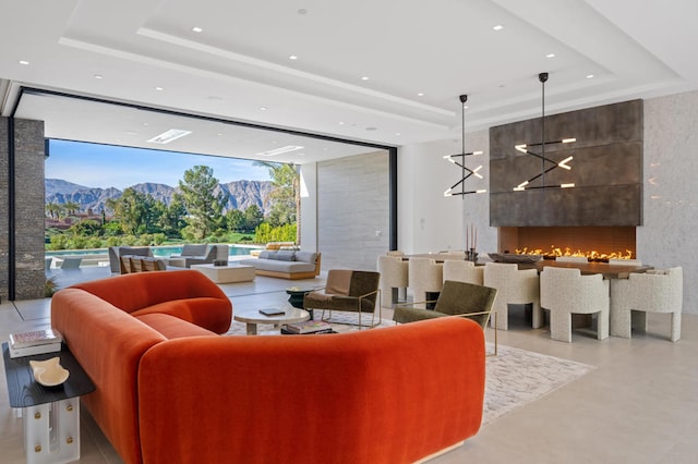 living room featuring a mountain view, a raised ceiling, and a chandelier