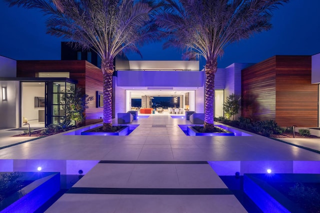 pool at night featuring a patio