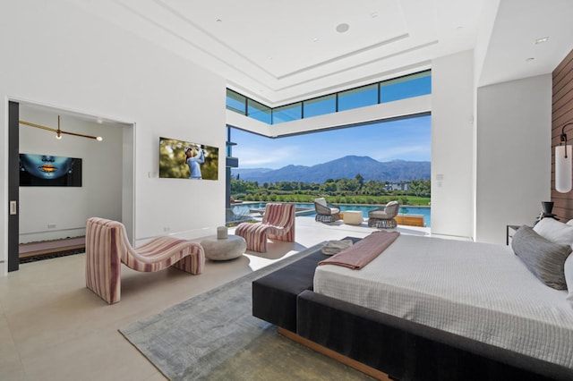 bedroom featuring a high ceiling and concrete flooring