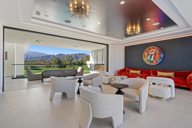 interior space featuring an inviting chandelier, a mountain view, and a raised ceiling