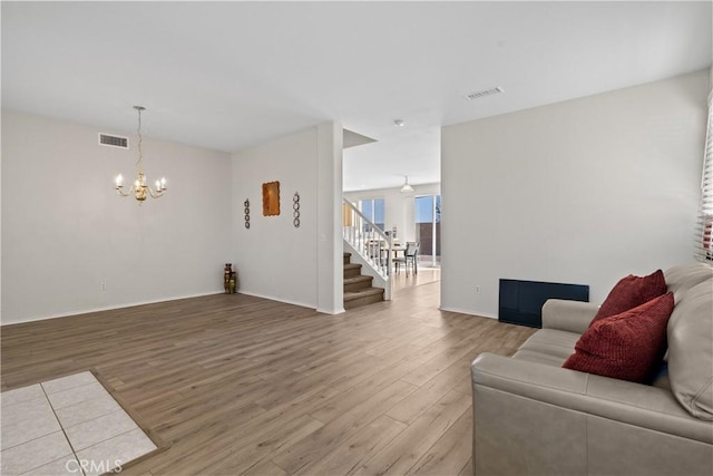 9179 Ravenswood Ave, Hesperia, CA 92344 - living room with stairway, a chandelier, visible vents, and light wood-type flooring