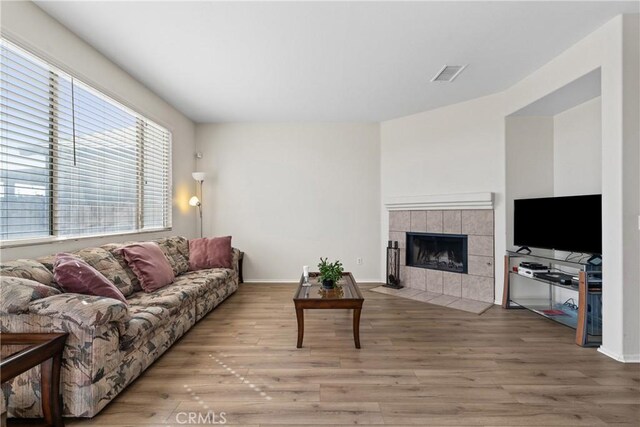 9179 Ravenswood Ave, Hesperia, CA 92344 - living room with baseboards, wood finished floors, visible vents, and a tile fireplace