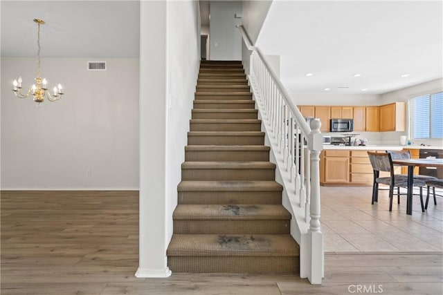 9179 Ravenswood Ave, Hesperia, CA 92344 - staircase with recessed lighting, wood finished floors, visible vents, baseboards, and a chandelier