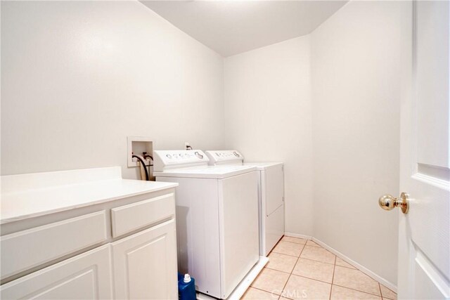 9179 Ravenswood Ave, Hesperia, CA 92344 - laundry area with washing machine and dryer, baseboards, cabinet space, and light tile patterned floors