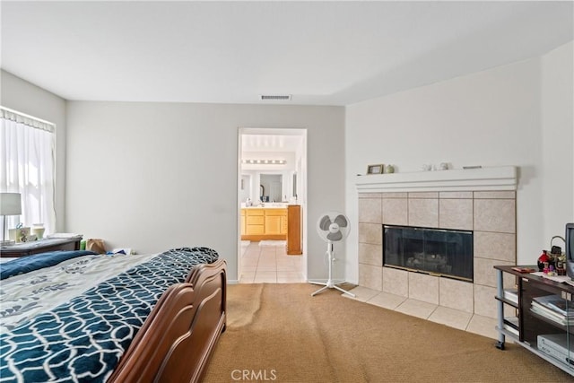 9179 Ravenswood Ave, Hesperia, CA 92344 - tiled bedroom featuring a tiled fireplace, visible vents, carpet floors, and ensuite bathroom