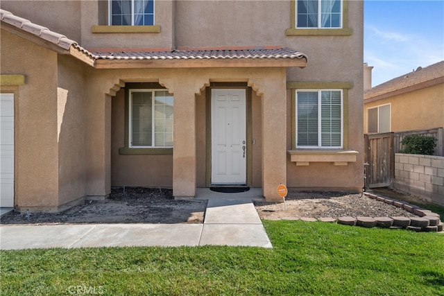 entrance to property featuring a yard