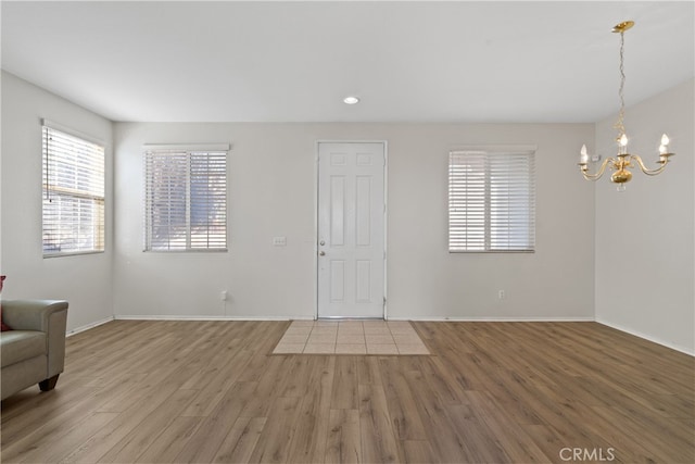 foyer with hardwood / wood-style floors and a notable chandelier