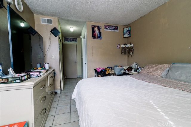 bedroom with a textured ceiling and light tile patterned floors