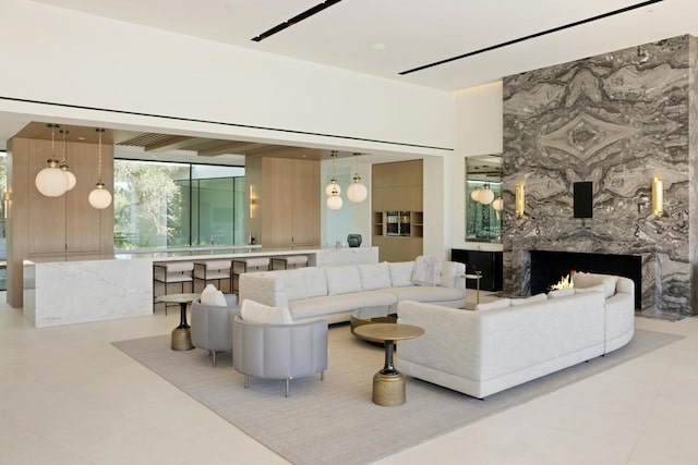 living room with a fireplace and light tile patterned flooring