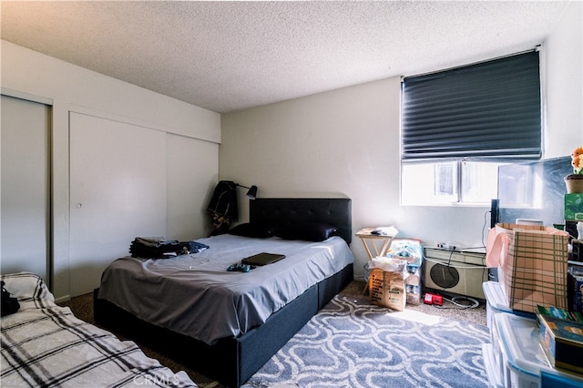 carpeted bedroom featuring a closet and a textured ceiling