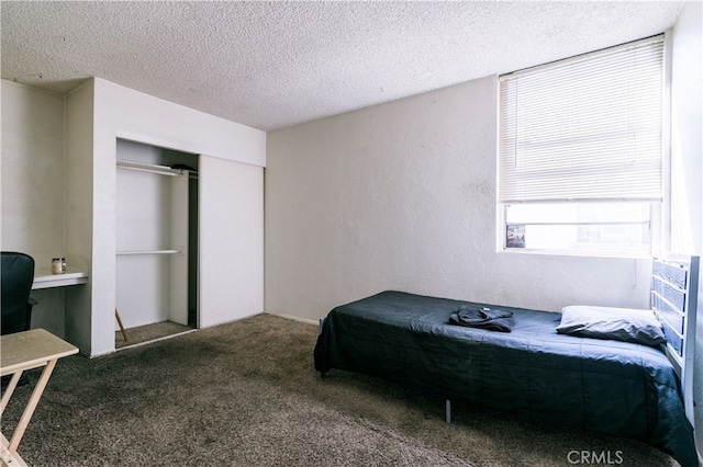 carpeted bedroom featuring a textured ceiling and a closet