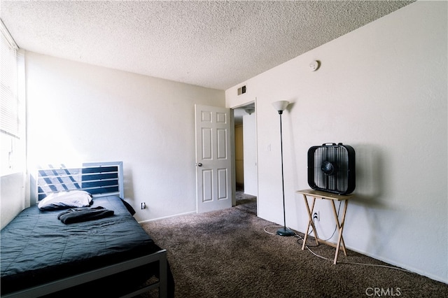 bedroom with a textured ceiling and carpet flooring