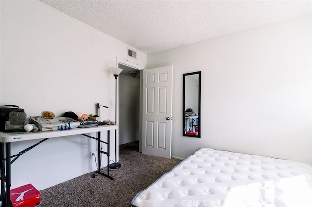 bedroom featuring a textured ceiling and dark colored carpet