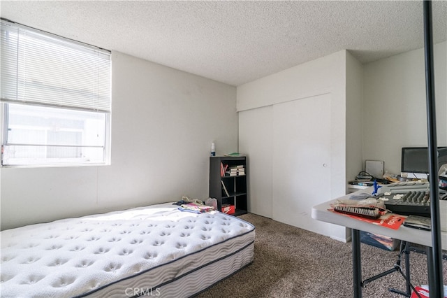 carpeted bedroom featuring a closet and a textured ceiling