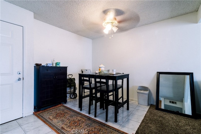 dining room featuring ceiling fan and a textured ceiling