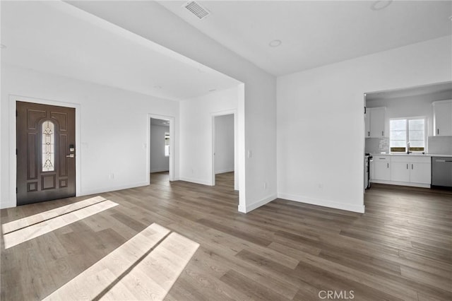 unfurnished living room with sink and hardwood / wood-style floors