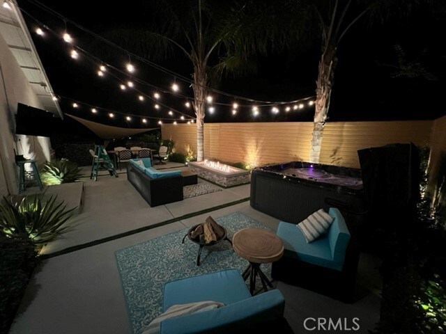 patio at twilight featuring outdoor lounge area and a hot tub