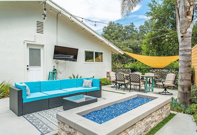 view of patio with an outdoor living space with a fire pit