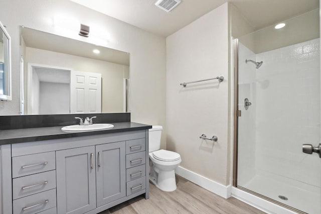 bathroom with walk in shower, wood-type flooring, vanity, and toilet