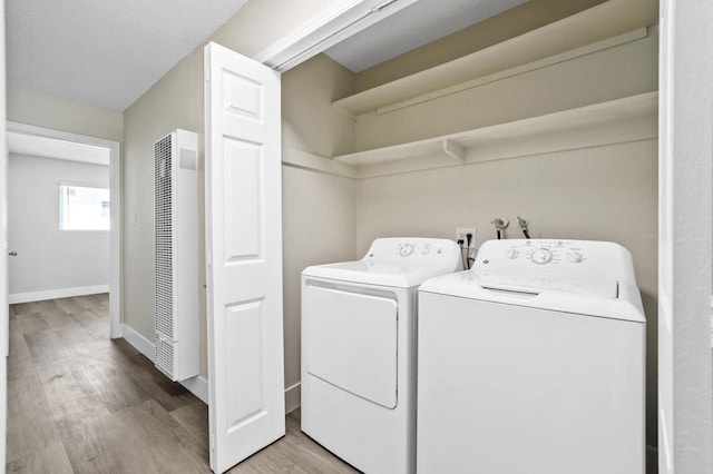 washroom with light hardwood / wood-style flooring and washing machine and clothes dryer